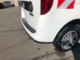 a white van with red and white stripes parked in a parking lot