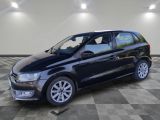 une Volkswagen B noire garée en épi sur un sol à damier