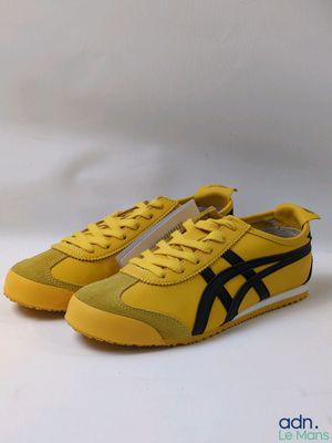 une paire de baskets jaunes et noires sur fond blanc