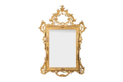 un miroir au cadre doré ouvragé accroché à un mur blanc