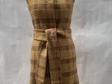beige and brown checkered dress on display in front of a white backdrop