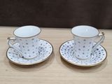 deux tasses et soucoupes sont posées sur une table en bois