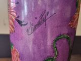 a purple vase with a dragon on it sitting on a table
