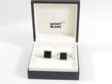 une paire de boutons de manchette noirs et blancs dans un coffret cadeau