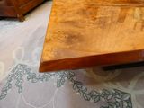 une table en bois avec un plateau en verre posée sur un tapis