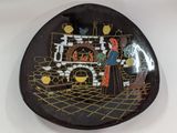 a black plate with a picture of a woman and a fireplace
