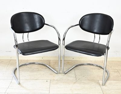 une paire de chaises chromées et noires devant un mur blanc dans une pièce