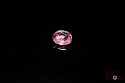 un diamant rose sur une surface noire