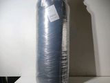 un grand rouleau de tissu bleu emballé dans du plastique, posé sur une table