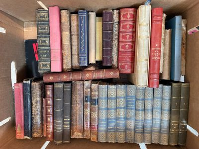 a box full of old books sitting on top of each other