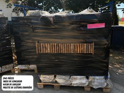 two pallets of black marble on pallets in front of a building