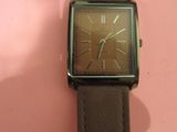une montre posée sur une surface rose