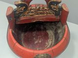 a red bowl with a handle on a white table