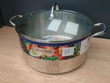 une casserole en inox avec un couvercle posée sur une table en bois