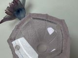 a bird that is sitting next to a glass bowl