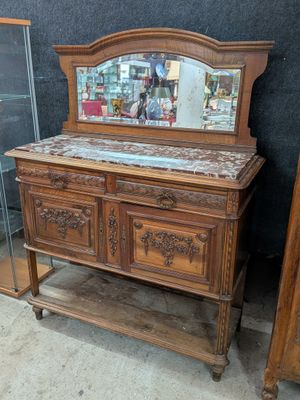 une commode en bois surmontée d'un miroir