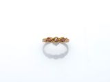 a close up of a gold ring with two pink stones