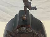 a clock that has a statue of a boy on top of it