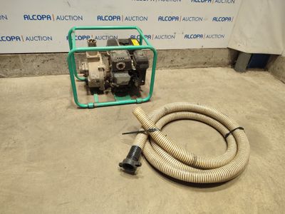 a hose and a pump on the ground next to a sign