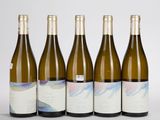 six bouteilles de vin sont alignées sur une table
