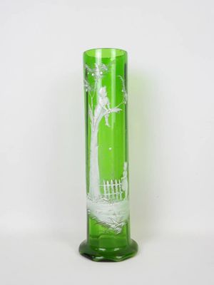 tall green glass vase with a tree and a fence on it