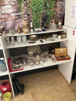 une étagère blanche sur laquelle sont posés des casseroles et des poêles, dans une pièce
