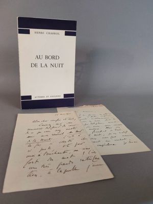 un livre ouvert posé sur une table à côté d'une feuille de papier