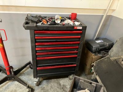 une armoire à outils sur laquelle sont posés des outils, dans un garage