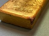 a gold bar sitting on a table with water droplets on it