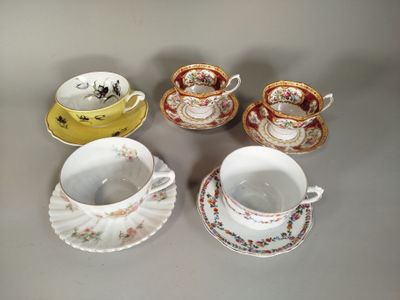 quatre tasses et soucoupes sont alignées sur une table