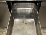a stainless steel sink in the middle of a tiled floor