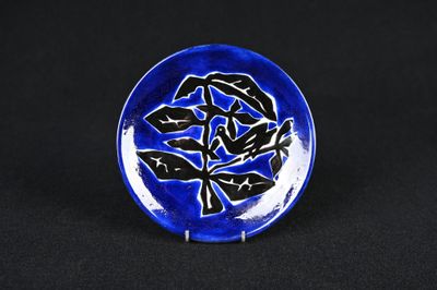 un gros plan d'une assiette bleue et noire ornée d'une fleur