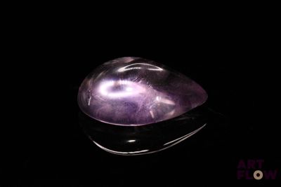 a close up of a purple quartz stone on a black surface