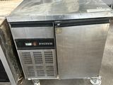 a stainless steel refrigerator sitting in the middle of a warehouse