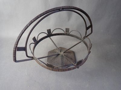 a metal basket with a fan inside of it on a table