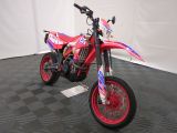 a red dirt bike that is parked on the floor