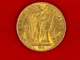 a close up of a gold coin on a red surface