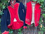 deux vestes accrochées à un mur, à côté d'un buisson