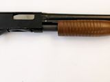 fusil posé sur une surface blanche, avec une crosse et un canon en bois