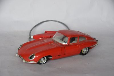 a red toy car that is sitting on a white surface