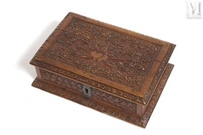an old wooden box with a bird design on the lid