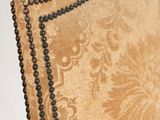 an upholstered upholstered chair with beading on the back of it