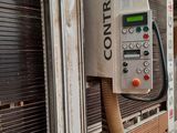 a control panel on the side of a building with a hose attached to it