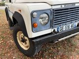 a white land rover parked on the grass in front of a house