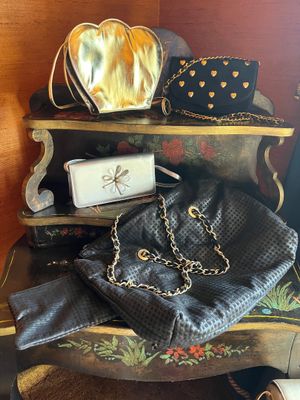 several purses are stacked on top of each other on a shelf