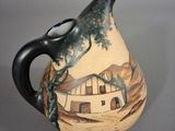 a vase with a painting on it sitting on a table