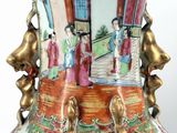 a vase with a painting on it sitting on a table