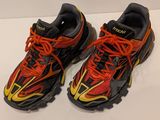 pair of red and black running shoes with orange laces on them