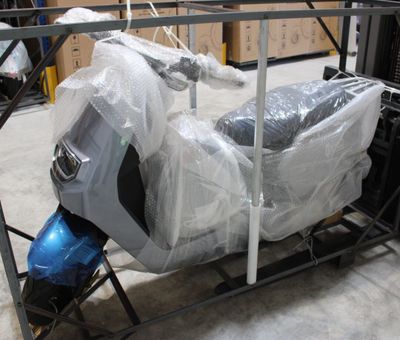 un scooter emballé dans du plastique et posé sur un chariot