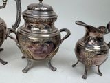 three silver teapots sitting next to each other on a table